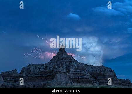 Ein aktiver Gewitter über den Bergen des Badlands National Park in South Dakota erhellt den Himmel. Stockfoto