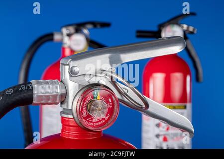 Ein klassisches rotes Feuerlöscherventil auf blauem Hintergrund für den Einsatz als Designelement oder Sicherheitselement für den Schutz von Haus und Betrieb. Stockfoto