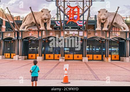 Detroit, Michigan, USA. Juli 2020. Ein Junge steht vor dem Eingang zum Comerica Park während eines Baseballspiels zwischen den Detroit Tigers und den Kansas City Royals. Zuschauern ist es aufgrund der Coronavirus-Pandemie untersagt, das Stadion zu betreten. Kredit: Jim West/Alamy Live Nachrichten Stockfoto