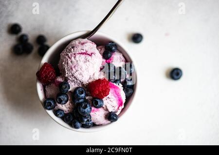 Obst Sommer Eis Dessert mit frischen Bio-Beeren von Heidelbeere serviert in Schüssel auf Stein Hintergrund mit Kopierer Platz Stockfoto