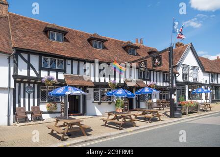 Das Queens Head Pub bei Sommersonne. Tische und Bänke mit Sonnenschirmen stehen auf dem Bürgersteig. High Street, Pinner, Middlesex, England, Großbritannien Stockfoto