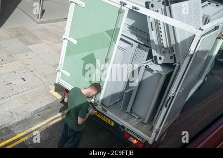 Der Fahrer eines Lieferwagens voller zu verwertenden Metallgegenstände verwendet am 30. Juli 2020 in London, England, ein Zustellgerät am Heck seines Fahrzeugs. Stockfoto