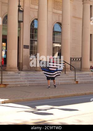 Oneonta, NY / USA - 31. Juli 2020: Ein Protestler am Rathaus schwenkt eine "blaue Linie"-Flagge in Opposition zu einer City-genehmigten BLM-Gedenkfeier auf der St. Stockfoto