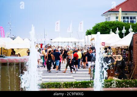 Überfüllte Touristen an der polnischen Küste während Pandemieurlaub in Sopot, erschossen zwischen Brunnen mit unkenntlichen Gesichtern während bewölkten Tag mit weichem Licht Stockfoto