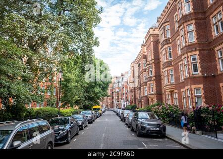 London, Juli, 2020: Wohnstraße von schönen roten Backstein Reihenhäuser London Stadthäuser in Kensington Court, West London Stockfoto