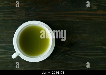 Blick von oben auf eine Tasse heißen Matcha Grüner Tee isoliert auf Block Holztisch Stockfoto