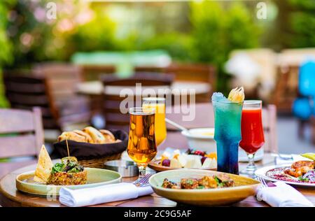Leckere Mahlzeiten, Cocktail, Brot auf der Terrasse Restaurant Tisch Stockfoto
