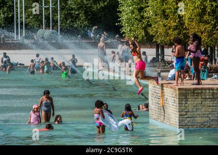 London, Großbritannien. Juli 2020. Der bisher heißeste Tag des Jahres führt Familien dazu, in Zierteichen im Battersea Park zu schwimmen, um sich abzukühlen. Die Pools haben klare Warnschilder, die Gefahr sagen und nicht ins Wasser gehen. Die Lockerung des Coronavirus-Ausbruchs (Covid 19) in London dauert an. Kredit: Guy Bell/Alamy Live Nachrichten Stockfoto