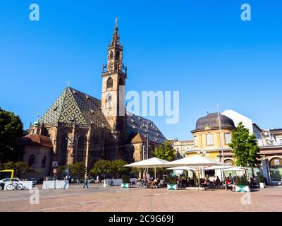 Der Dom von Bozen ist eine restaurierte spätgotische Kirche mit einem gemusterten, mehrfarbigen Marmordach und einem kunstvollen Turm Stockfoto