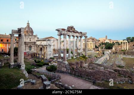 Der Vespasianus- und Titus-Tempel (links), der Septimius-Severus-Bogen (Mitte) und der Saturn-Tempel (rechts) im Forum Romanum - Rom, Italien Stockfoto