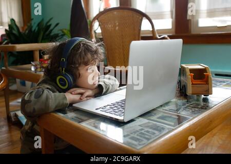 Ein kleiner Junge, der vor einem Laptop lernt Stockfoto