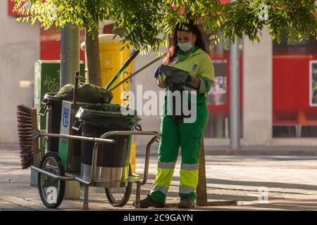 Madrid, Spanien - 19. Mai 2020: Eine Arbeiterin in ihren täglichen Reinigungsarbeiten, am Morgen, auf den Straßen von Madrid, im Retiro-Viertel. Stockfoto