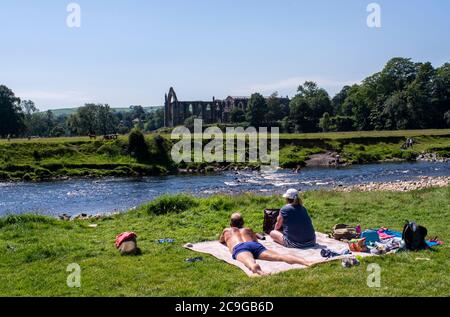 Bolton Abbey, Skipton, Großbritannien. Juli 2020. Menschen, die heute in der heißen Hitze auf dem Gelände der Abtei von Bolton sonnenbaden und herumtoben. Kredit: ernesto rogata/Alamy Live Nachrichten Stockfoto