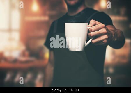 Barista gibt eine Tasse heißen Kaffee im Laden Stockfoto
