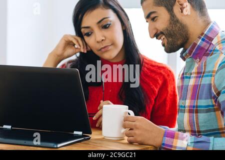 Zwei junge Kollegen, die auf einen Computerbildschirm schauen In einem Büro Stockfoto