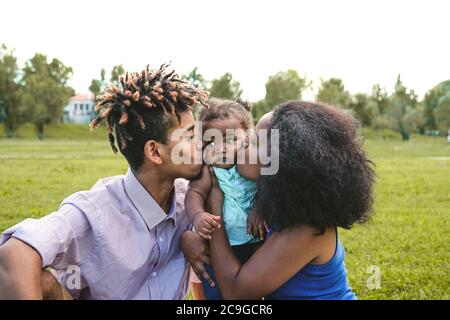 Glückliche afrikanische Familie Spaß zusammen im öffentlichen Park - Schwarzer Vater und Mutter genießen Wochenende mit ihrer Tochter Stockfoto