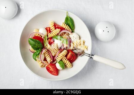 Caprese Nudelsalat mit Tomaten, Mozzarella-Käse, Basilikum. Stockfoto