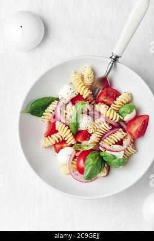 Caprese Nudelsalat mit Tomaten, Mozzarella-Käse, Basilikum. Stockfoto