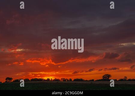 Schöner feuriger Himmel und Wolken während des Sonnenuntergangs, Blick auf den Sommerabend Stockfoto