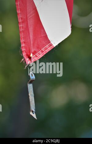 Dose und Flaschenöffner, die als Gewicht verwendet werden, um USA-Flagge vom Flattern im Flügel mit einem Baby-Sicherheitsnadel zu halten Stockfoto