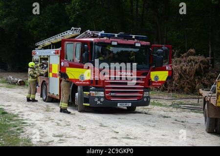 31. Juli 2020 - ein altes Lagerfeuer brennt auf Ackerland in Newchapel bei Lingfield in Surrey. Ein einziges Feuergerät nimmt in weniger als 11 Minuten vom East Grinstead ab und erhält die Kontrolle, um die Ausbreitung auf nahe gelegene Wälder zu verhindern. Die übermäßige Hitze von 32C, starkes Sonnenlicht und starke Brise waren alle Faktoren, die zu seiner Selbstverbrennung und seine Neigung, zu versuchen, Feuer in den Wald zu setzen. Stockfoto