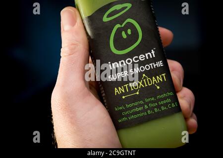 ANTWERPEN, BELGIEN - Nov 11, 2019: Illustrative Editorial: Hand hält grünen unschuldigen antioxidativen Smoothie mit Kiwi, Banane, Limette, Matcha, Gurke an Stockfoto