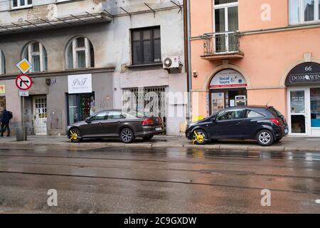 Krakau, Polen - 18. Juli 2020: Zwei Autos mit geklemmter Fahrzeugradsperre an der Straße in Europa gesperrt Stockfoto