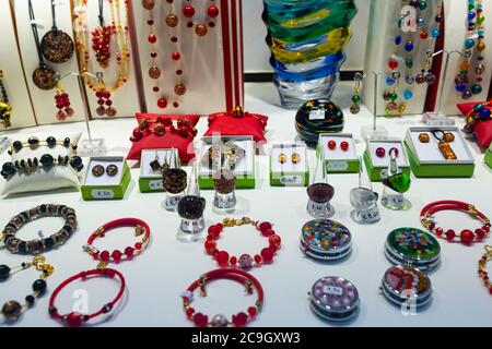 Originelle bunte Schmuckstücke aus dem berühmten Murano-Glas auf Regalen des Souvenirshops in Venedig Stockfoto