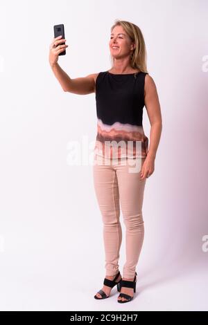 Reife schöne blonde Geschäftsfrau vor weißem Hintergrund Stockfoto