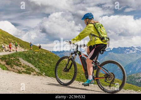 Mountainbiker, blond, Anfang 50 auf alpiner Schotterstraße, Serfaus, Tirol, Österreich Stockfoto