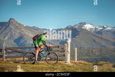 Mountainbiker, Ende 40er Jahre, fährt eMTB auf Singletrail in der herbstlichen Berglandschaft der Stubaier Alpen, Bergeralm Freizeitarena, Bikepark Stockfoto