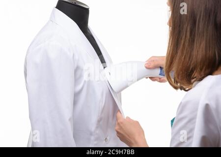 Mädchen behandelt medizinische Kleidung von Dampfer auf weißem Hintergrund Stockfoto