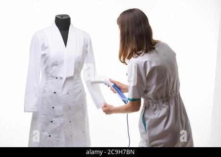 Mädchen in medizinischer Kleidung Griffe Dampf Kleidung auf Maniküre Stockfoto