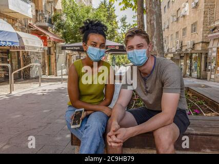 Jerusalem, Israel - 30. Juli 2020: Ein paar junge israelis, die COVID-Masken tragen, auf einer fast schäbigen Jerusalem, Israel, Straße. Stockfoto