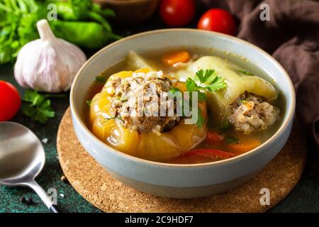 Gesunde Ernährung. Paprikaschoten gefüllt mit Fleisch und Bulgur in Brühe mit Gemüse. Stockfoto