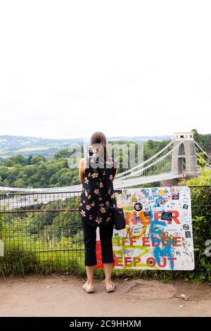 Eine Touristin, die mit ihrem Handy ein Foto von Isambard Kingdom macht Brunel Clifton Hängebrücke über die Avon Gorge, zwischen Clifton und Leigh Stockfoto