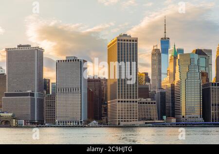 Blick auf die Wolkenkratzer des New York City Financial District bei Sonnenuntergang, aufgenommen vom Brooklyn Bridge Park in DUMBO Stockfoto