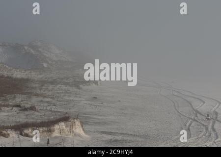 Nebel über Strand mit Reifenspuren Stockfoto