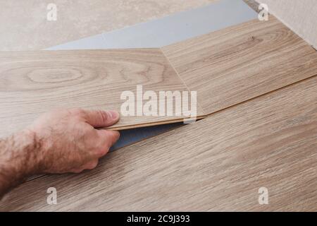 Schritt-für-Schritt-Anleitung zum Verlegen von Laminatböden - Verbinden von Lamellen mit Quer- und Längsverriegelung Stockfoto