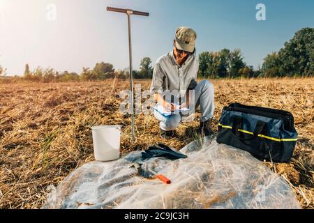 Bodenprüfung. Weibliche Agronomin Notizen auf dem Feld. Stockfoto