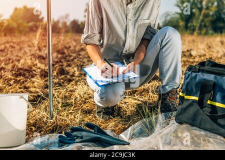 Bodenprüfung. Weibliche Agronomin Notizen auf dem Feld. Stockfoto