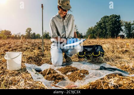 Bodenprüfung. Weibliche Agronomin Notizen auf dem Feld. Stockfoto