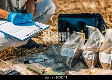 Bodenprüfung. Weibliche Agronomin Notizen auf dem Feld. Stockfoto