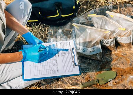 Bodenprüfung. Weibliche Agronomin Notizen auf dem Feld. Stockfoto