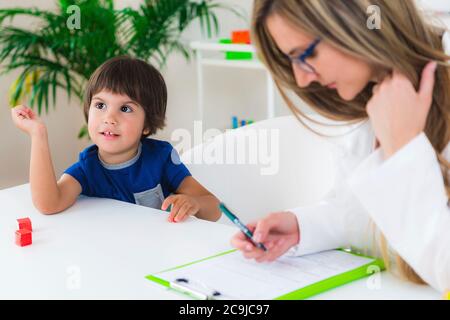 Kinderpsychologie, kleiner Junge im Gespräch mit Psychologe. Stockfoto