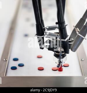 Roboterhandhabmaschine für die Pharmaindustrie. Roboterarm erkennt und kommissioniert nur Produkte, die den gewünschten Eigenschaften entsprechen. Stockfoto