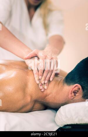 Sportmassage. Physiotherapeut massiert Mann den Hals. Stockfoto