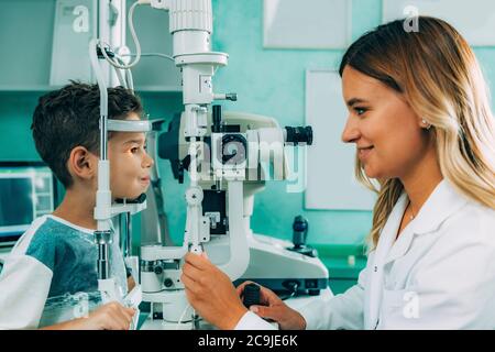 Augenarzt untersucht Jungen Augen mit einem Schlitz Lampe. Stockfoto