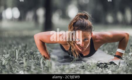 Weibliche Sportlerin macht Liegestütze im Freien. Stockfoto