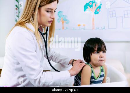 Kinderarzt untersucht Junge mit Stethoskop. Stockfoto